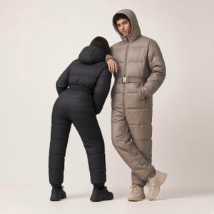 Puede incluir: Un mono acolchado con capucha negro con cinturón a juego y zapatillas negras, y un mono acolchado con capucha color topo con cinturón a juego y zapatillas beige. Ambas prendas presentan costuras horizontales y cremallera frontal.