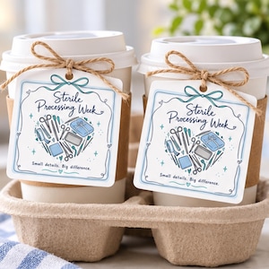 May include: Two white disposable coffee cups with brown cardboard sleeves, each featuring a square white tag tied with twine. The tags display the text Sterile Processing Week and Small details. Big difference. with a heart-shaped medical tool graphic.