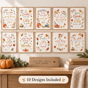 May include: Ten framed wall art prints featuring autumn-themed illustrations of pumpkins, leaves, and birds, each with religious text. A wooden block with the engraved text 'FAITH FILLS OUR HOME' sits below the prints on a wooden surface.