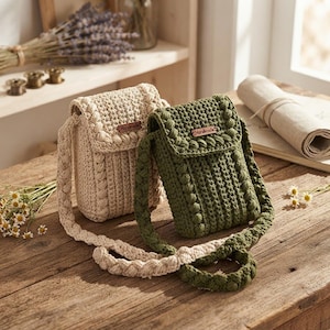 May include: Two small rectangular crochet crossbody bags, one in cream and one in olive green. Each bag features a textured bobble stitch pattern, a flap closure with a small brown rectangular tag labeled Handmade, and a thick braided shoulder strap.