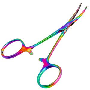 May include: A pair of rainbow-coloured hemostatic forceps with a metallic finish. The tool features two finger loops, a locking mechanism, and curved, serrated tips. The text 'Swann-Morton ENGLAND' is printed on the hinge area of the instrument.