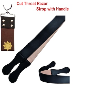 May include: A cut throat razor strop with handle featuring a long black leather strap with a beige underside. The top section includes a brown leather tab with four silver rivets, a metal hanging ring, and a star-shaped logo reading Real Leather.