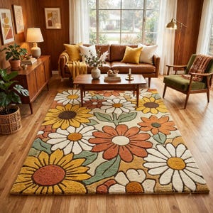 May include: A rectangular area rug featuring a repeating floral pattern of large daisies and sunflowers in shades of yellow, orange, cream, and sage green. The rug has a textured, tufted pile surface with distinct petal shapes and central circular centers.