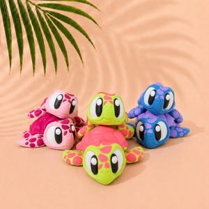 May include: Three sets of stacked turtle figurines. The left set is pink with darker pink spots. The center set is lime green with bright pink spots. The right set is blue with purple spots. Each turtle has large white eyes with black pupils.
