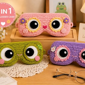 Puede incluir: Tres estuches de ganchillo para gafas en rosa, verde y morado, cada uno con grandes ojos circulares, pequeñas bocas bordadas y detalles florales. El estuche rosa muestra el texto 3 IN 1 CUTE GLASSES CASE. Estos estuches sirven para guardar gafas.