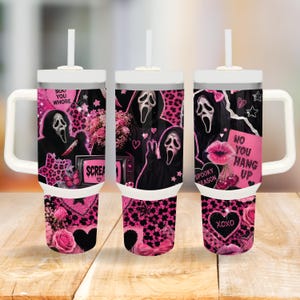 Può includere: Un bicchiere bianco con manico e cannuccia caratterizzato da una stampa grafica nera e rosa della maschera di Ghostface, rose rosa, motivi leopardati e testi tra cui "Boo You Whore", "Scream", "Spooky Season", "No You Hang Up" e "XOXO".