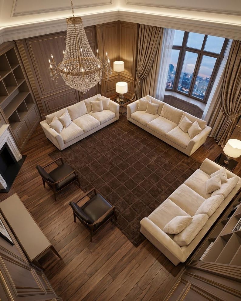 May include: A living room featuring three cream-colored sofas, two dark brown leather armchairs, and a large square brown rug. A crystal chandelier hangs from the ceiling above the seating area, which is surrounded by wood-paneled walls.