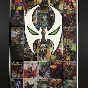 May include: A rectangular poster featuring a collage of various Spawn comic book covers arranged in a grid. Overlaid in the centre is a large, white, stylised mask graphic with sharp, angular edges and two almond-shaped green eye cutouts.