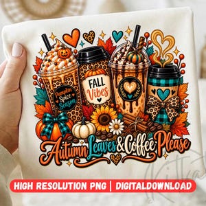 Puede incluir: Una camiseta blanca con un gráfico colorido de tres tazas de café, calabazas, girasoles y hojas de otoño. El texto dice "Pumpkin Spice Season", "Fall Vibes" y "Autumn Leaves & Coffee Please" en fuentes decorativas y de bloque.