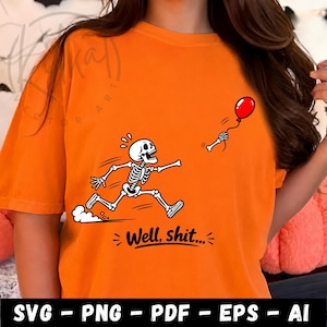 Op de afbeelding: Een oranje t-shirt met een afbeelding van een wit skelet dat achter een wegvliegende rode ballon aan rent. Het skelet kijkt verrast. Onder de afbeelding staat de tekst "Well, shit..." in een vetgedrukt zwart cursief lettertype.