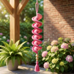 Peut inclure: Une décoration en spirale suspendue faite de fil rose et rose clair, présentant une forme torsadée en tire-bouchon. L'ornement comprend une boucle en haut pour la suspension, trois perles en bois lisses et un pompon en fil rose en bas.