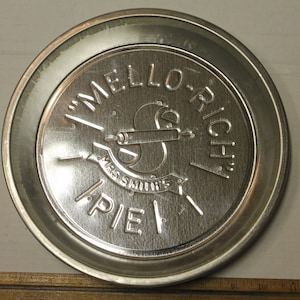 May include: A silver pie pan with the words "Mello-Rich Mrs. Smith's Pie" embossed on the front.