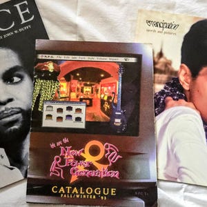 May include: Three Prince-related publications including a black and white biography book titled PRINCE, a New Power Generation Fall/Winter '93 catalogue featuring a guitar and band imagery, and an Emancipation words and pictures booklet with a color portrait.
