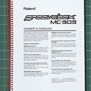 May include: A white owner's manual for the Roland Groovebox MC-303 with a red spiral binding. The cover features black text including the brand name, model number, and a detailed list of technical features such as the sequencer and sound set.