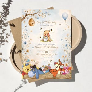 Può includere: Un invito di compleanno con Winnie the Pooh, Tigro, Ih-Oh, Pimpi e Ro. Il testo recita Our little hunny is turning one, please join us to celebrate Olivia's 1st Birthday, Saturday 22 June, 123 Anywhere, anycity, any country, rsvp to 123456789.