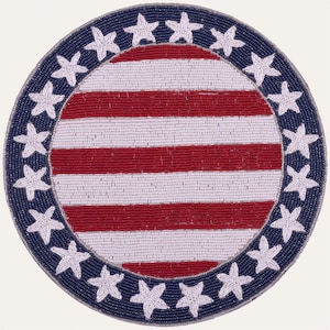 May include: A circular beaded placemat featuring a central design of horizontal red and white stripes. The border is a deep blue band decorated with twelve white beaded stars arranged in a circle around the striped center of the placemat.