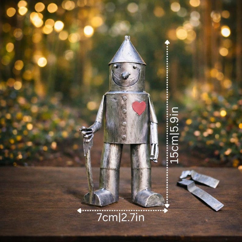 May include: A silver-colored metal robot figurine with a conical hat, a red heart on its chest, and a small axe in its right hand. The figure stands 5.9 inches tall and 2.7 inches wide, as indicated by the visible measurement markings.