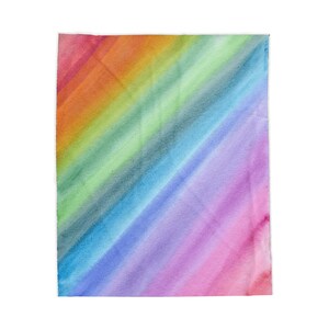 May include: A rectangular blanket featuring a vibrant watercolor design with diagonal stripes in a rainbow spectrum. The colors transition smoothly from red and orange at the top left corner to yellow, green, blue, indigo, and violet toward the bottom right.