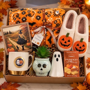 ハロウィンギフトボックス（女性向け）、ブランケット、パンプキンスリッパ、マグカップ、ゴーストデコレーションが入った居心地の良い秋のギフトバスケット