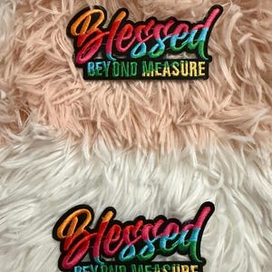 May include: Two embroidered patches featuring the word Blessed in a multi-colored gradient script font above the words BEYOND MEASURE in a block font. The embroidery uses orange, pink, blue, and green thread on a black background.