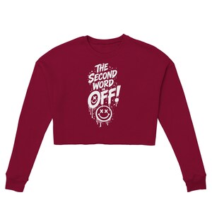 Könnte beinhalten: Ein bordeauxrotes langärmeliges bauchfreies Sweatshirt mit weißem Grafiktext, der THE SECOND WORD IS OFF! lautet, mit einem tropfenden Farbeffekt und zwei Smileys mit X-förmigen Augen, die im Schriftzug und darunter platziert sind.