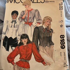 May include: A vintage McCall's sewing pattern for a women's blouse. The pattern is for size 31 1/2 and includes four different styles of blouses. The pattern is from Norton Simon Inc. Company and costs $3.00.