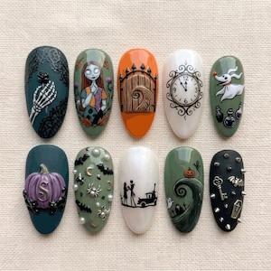 May include: A set of ten press-on nails featuring Nightmare Before Christmas designs. The nails display detailed illustrations of characters, a clock, a pumpkin, a gate, bats, spiders, pearls, metal studs, a key, and a coffin on various colored backgrounds.