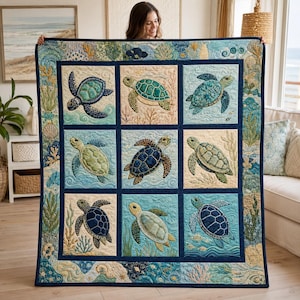 Könnte beinhalten: Ein rechteckiger Quilt mit einem Raster aus neun quadratischen Feldern, die jeweils eine Meeresschildkröte in Blau-, Grün- und Cremetönen zeigen. Der Rand ist mit Wasserpflanzen, Korallen und Muscheln verziert, alles in gesteppter Textur.
