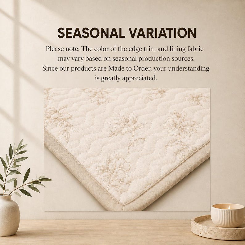 K&ouml;nnte beinhalten: Ein cremefarbener, gesteppter Stoff mit hellbraunem Blumenmuster und einem einfarbigen Rand. Der Text lautet: SEASONAL VARIATION. Bitte beachten Sie: Die Farbe der Kanten und des Futters kann je nach saisonaler Produktion variieren.