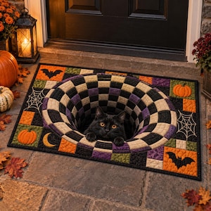 May include: A rectangular floor mat featuring a black cat emerging from a central 3D-effect black and white checkered hole. The border displays a patchwork pattern of orange pumpkins, black bats, white spiderwebs, and yellow crescent moons.