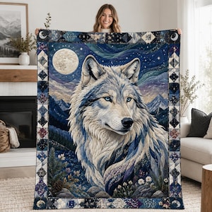 May include: A rectangular quilt featuring a large, detailed portrait of a wolf with blue eyes. The background depicts a mountain landscape under a starry night sky with a full moon. The border consists of a geometric pattern in shades of blue.
