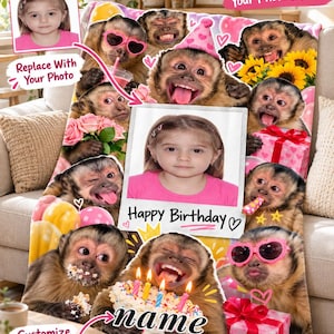 Pode incluir: Uma manta macia com uma colagem de macacos-prego em várias poses, incluindo alguns a usar óculos de sol cor-de-rosa em forma de coração e chapéus de festa. O centro exibe uma moldura personalizável com o texto Happy Birthday e name.