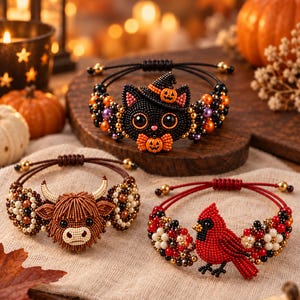 Könnte beinhalten: Drei Perlenarmbänder mit detaillierten Motiven: eine schwarze Katze mit Kürbishut und Fliege, ein braunes Hochlandrind mit strukturierten Hörnern und ein leuchtend roter Kardinalvogel, verziert mit bunten Perlen und verstellbaren Kordeln.