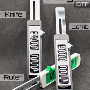 Könnte beinhalten: Drei Fidget OTF-Werkzeuge in Grau, Weiß und Grün. Eines verfügt über eine Messerklinge, eines über einen Kamm und eines über ein Lineal mit Markierungen. Jedes Werkzeug hat einen rechteckigen Griff mit silbernem Schiebemechanismus und Wellenmuster.