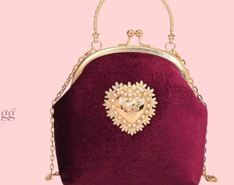 Sac à main en velours bordeaux avec médaillon cœur doré et fermoir clic-clac