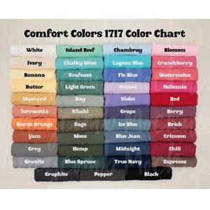 May include: A Comfort Colors 1717 color chart displaying a grid of folded t-shirts in various shades. The text at the top reads Comfort Colors 1717 Color Chart. The colors include white, ivory, banana, butter, mustard, terracotta, orange, yam, grey, granite, and black.