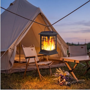 May include: A black rectangular lantern with a handle, featuring a simulated flame effect inside. The lantern has a geometric frame design and is suspended from a rope, emitting a warm orange glow that mimics the appearance of a real fire.