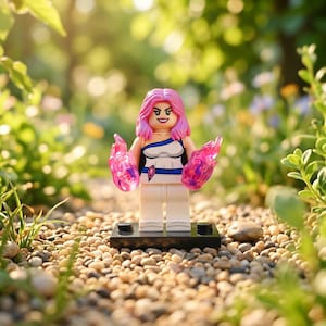 Könnte beinhalten: Eine Kunststoff-Minifigur mit rosa Haaren in einem weiß-blauen Outfit, die auf einem schwarzen rechteckigen Sockel steht. Die Figur hat an jeder Hand durchscheinende rosa Energieeffekte und ein aufgedrucktes Gesicht mit selbstbewusstem Ausdruck.
