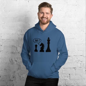 May include: A blue hooded sweatshirt featuring a black graphic print of a chess pawn, a knight, and a king. The pawn has a speech bubble above it containing the text NI!. The hoodie includes a front kangaroo pocket and long sleeves.