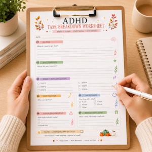 May include: An ADHD task breakdown worksheet on a brown clipboard with a gold clip. The paper features sections for big tasks, importance, small steps, time estimates, and rewards, decorated with autumn leaves and pumpkins, with text in English.