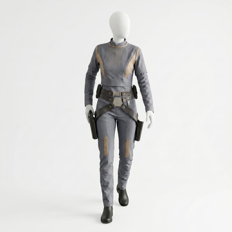 May include: A grey long-sleeved top and matching trousers set on a mannequin. The outfit features tan accents on the chest and legs, a dark brown utility belt with a central buckle, and two dark brown holsters attached to the sides of the belt.