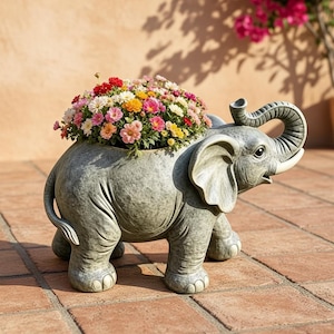 Può includere: Un vaso a forma di elefante grigio con finitura testurizzata, caratterizzato da una proboscide sollevata e grandi orecchie. Il dorso cavo dell'elefante è riempito da una densa composizione di piccoli fiori vivaci nei toni del rosa, rosso, giallo e bianco.
