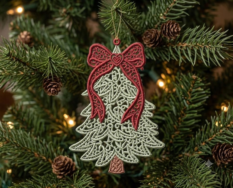 K&ouml;nnte beinhalten: Ein Weihnachtsbaumschmuck aus hellgr&uuml;nem Faden in einem zarten Spitzenmuster, mit einer auff&auml;lligen dunkelroten Stickschleife an der Spitze, die ein herzf&ouml;rmiges Detail in der Mitte aufweist, und einem kleinen braunen Stamm an der Basis, aufgeh&auml;ngt an einer goldenen Schnur.