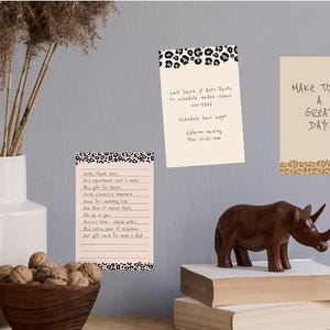 May include: Two rectangular paper note cards with leopard print borders at the top and bottom. One card features a handwritten to-do list, while the other contains handwritten notes including call Jason at Auto Parts and schedule hair appt.