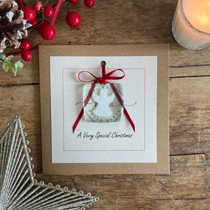 Una Navidad muy especial. Tarjeta hecha a mano con un ángel blanco de vidrio fundido como recuerdo para siempre. Tarjeta navideña especial y única.