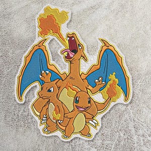 Puede incluir: Un parche bordado que muestra una gran criatura naranja similar a un dragón con alas azules escupiendo fuego, situada detrás de dos criaturas naranjas más pequeñas similares a lagartos, una de ellas con una llama en la cola.