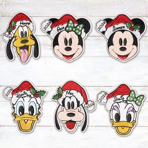 Könnte beinhalten: Sechs bestickte Aufnäher mit den Charakteren Pluto, Minnie Maus, Mickey Maus, Donald Duck, Goofy und Daisy Duck. Jede Figur trägt eine rote Weihnachtsmütze mit der Jahreszahl 2026 und einem personalisierten Namen in schwarzer Schrift.