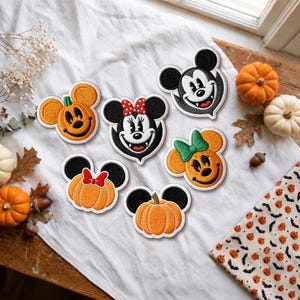 May include: Six embroidered patches featuring Mickey and Minnie Mouse designs. The patches include pumpkin-shaped heads with ears, a vampire-themed Mickey, and a vampire-themed Minnie with a red polka-dot bow, all with white stitched borders.