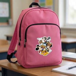 May include: A bright pink backpack featuring a large central graphic print of Disney characters including Mickey Mouse, Minnie Mouse, Donald Duck, Daisy Duck, Goofy, and Pluto. The bag has a main zippered compartment and a smaller front pocket.