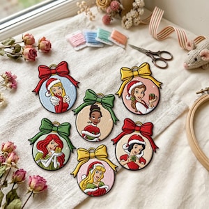 May include: Six circular embroidered patches featuring cartoon characters wearing Santa hats, each topped with a colorful fabric bow. The designs include various figures in festive attire, rendered with detailed stitching and vibrant thread colors.
